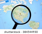 MONTREAL, CANADA - FEBRUARY, 2016 - USA with dollar sign on Google Maps under magnifying glass.