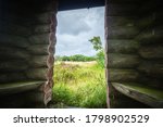 Small photo of Small shelter made of wooden logs in the wilderness. Wooden hut in the wild nature on a cloudy day. Take shelter i a small hut made of large woods logs