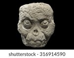 Small photo of Closeup fleshless stone Mayan skull from Copan, Honduras isolated on black background