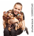 Small photo of Cute young girl holding Yorkshire terrier dogs on her lap over white