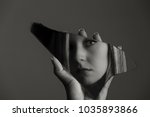 Woman looking at her face in a shard of an broken mirror artistic conversion