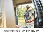 Small photo of Fruit grower loading car with apple crates
