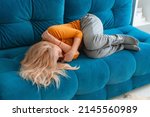 Small photo of depressed mature woman lying sofa with her arms around herself, covering her head with hands, unhappy woman suffering from insomnia depression, psychological problem, concept impotence, asthenia