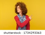 Small photo of Get out! Portrait of upset vexed woman with curly hair showing exit, demanding to leave her alone, turning away with resentful irritated expression. indoor studio shot isolated on yellow background
