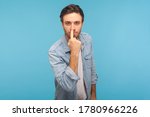 Small photo of Don't lie to me! Portrait of man in worker denim shirt touching nose, showing liar gesture, angry about falsehood, outright deception, fake news. indoor studio shot isolated on blue background