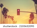 Santa Monica California Red Light and Palm Trees Conceptual Photo. United States of America. Scenic Sunset Warm Color Grading.