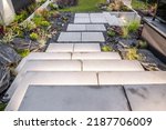 Small photo of Modern Residential Backyard Garden with Elegant Large Illuminated Concrete Stairs. Rockery Garden Design.
