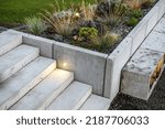 Small photo of Modern Rockery Garden and Small Concrete Architecture. Illuminated Outdoor Backyard Stairs.