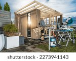 General Woodworker Building Elegant and Modern Garden Shed Which May Be Used as Backyard Sauna. 