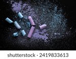 Small photo of Black Background With Light Lilac Pink and Light Blue Crushed Chalk. Small Pieces of School Chalk Lying on Spilled Powder. Layout Made of Crushed Pastel Pink and Blue Chalk. Flat Lay.