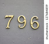 Small photo of cast bronze house number seven hundred and ninety-six on a gray wall