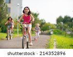 Three happy children riding on bicycle