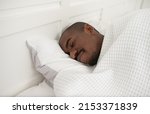 Small photo of Handsome young black man sleeping well alone on orthopaedic soft pillow under warm duvet, African American guy lying asleep in comfortable cozy bed enjoy good peaceful healthy sleep