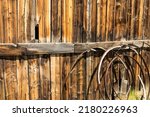 Background of old rusted wagon wheels against a weathered wood barn wall