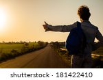 Young Man Hitchhiking on a Country Road