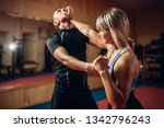 Female person on self-defense workout with trainer
