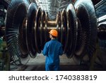 Small photo of Worker checks turbine impeller vanes on factory