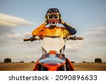Small photo of Portrait of motocross rider taking off helmet