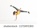 Small photo of Attractive young woman doing a freeze breakdance move over white background