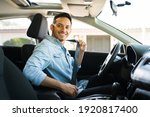 Small photo of Portrait of an attractive latin man smiling before starting to work as a taxi driver of a car sharing service on a mobile app
