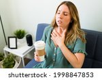 Small photo of Having a bad reaction to caffeine. Young woman touching her chest and suffering from tachycardia after drinking a strong cup of coffee