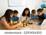 Interested smart teen students doing a collaborative project and teamwork during a robotics class and making a prototype