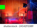 360-degree spinner photo booth setup with colorful laser lights, a green screen, and a camera on a tripod.