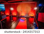 Small photo of 360 spinner photo booth setup with a red carpet and lighting in a venue with red ambient lighting.