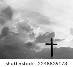 A christian cross under the dark sky.