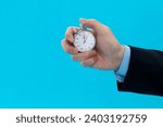 Businessman hand holding stopwatch on blue background