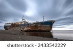 Small photo of Decaying ship on a foggy shore symbolizes neglect and temporal progression.
