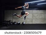 Small photo of A muscular man captured in air as he jumps in a modern gym, showcasing his athleticism, power, and determination through a highintensity fitness routine