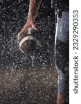 Small photo of Close up of American Football Athlete Warrior Standing on a Field focus on his Helmet and Ready to Play. Player Preparing to Run, Attack and Score Touchdown. Rainy Night with Dramatic lens flare