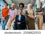 Small photo of In a spacious and modern startup office, a diverse group of business colleagues, including a colleague in a wheelchair, collaborates and interacts, exemplifying inclusivity, diversity, and teamwork in