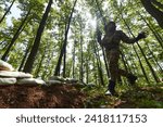 Small photo of An elite soldier adeptly clears military barriers in the perilous wooded terrain, showcasing tactical skill and agility during specialized training