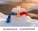 Cute snowman couple in love with snow heart between them.