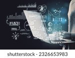 Close up of hacker hands holding and using laptop with creative toned business sketch on dark background. Business strategy and finance concept