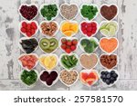 Diet detox super food & immune boosting food collection in heart shaped porcelain bowls over rustic wood background. Foods high in antioxidants, anthocaynins, omega 3, protein, vitamins & minerals.  