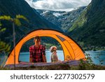Young Woman inside tent with dog. Beautiful view of Folgefonna Glacier and Buerdalen valley with Sandvevatnet lake. Traveling Norway 