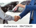 Handshake of two businessmen when selling a car in a motor show, close-up