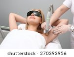 Blonde woman having underarm Laser hair removal epilation. Laser treatment in cosmetic salon