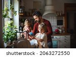 Small photo of Mature father with two small children washing dishes indoors at home, daily chores concept.