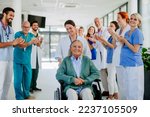 Small photo of Medical staff clapping to senior patient who recovered from serious illness.