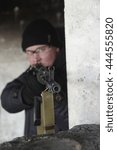 Small photo of machine gunner in black uniforms and protective glasses aim of the shelter