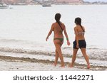 Two Girls Wallkin On The Beach