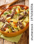 Small photo of Baeckeoffe French Alsatian Stew consisting of three types of meat, potatoes, onions and carrots close-up in a pot on the table. vertical