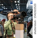 Small photo of New York, NY, USA - October 25th, 2019: Attendees examine new Nikon lenses at PDN PhotoPlus 2019 conference and expo at Javits Convention Center, Manhattan