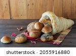 Small photo of Straight on view of a homemade bread cornucopia with rolls spilling out.