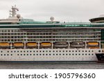 Small photo of Landscape view of the port side of a modern luxury cruise ship showing balcony staterooms, the Promenade Deck and lifeboats.