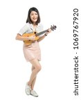 Small photo of Pretty emotional young Asian woman full body posing with ukulele isolated on white background.